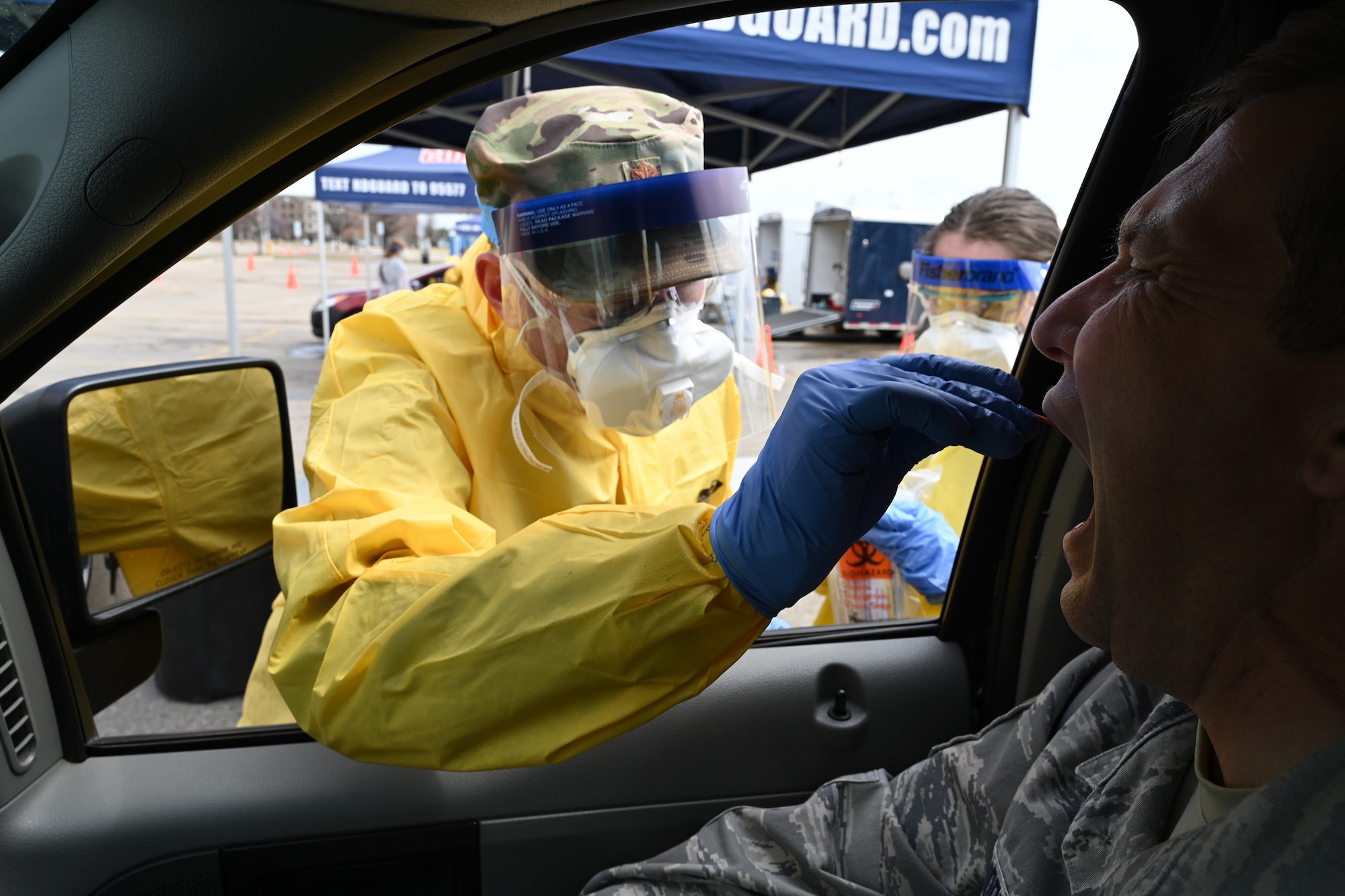 U.S. Air Force Maj. Chad Brooks, of the 119th Medical Group, takes a sample swab from an asymptomatic volunteer who is taking a COVID-19 test in the parking lot of the Alerus Center, Grand Forks, North Dakota, April 23, 2020. He’s wearing personal protective equipment to stay safe while he works, and to help prevent the spread of COVID-19 while testing people as they drive through in their vehicles. He is just one of the many North Dakota National Guard members partnering with the North Dakota  Department of Health and other civilian agencies in support of the community response to the COVID-19 pandemic. (U.S. Air National Guard photo by David H. Lipp)