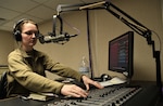 Senior Airman Oriana Beard works the sound board for her morning radio show
