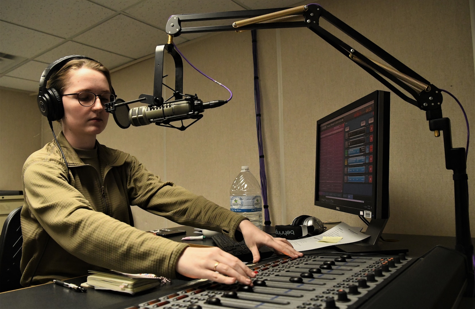 Senior Airman Oriana Beard works the sound board for her morning radio show