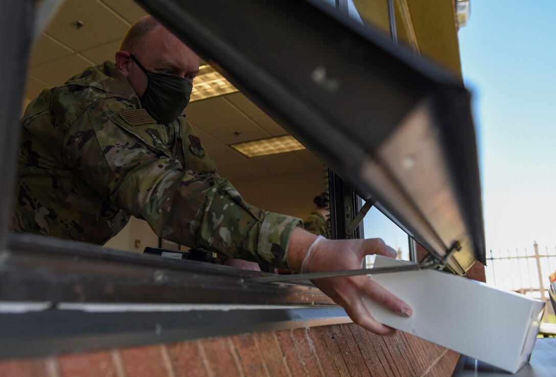 U.S. Air Force Capt. Ryan Ayers, 633rd Air Base Wing chaplain, passes a boxed lunch through a window during a 1st Fighter Friday lunch at Joint Base Langley-Eustis, Virginia, April 22, 2020.