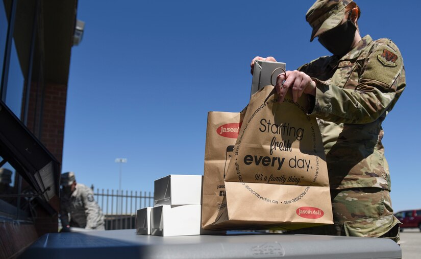 A U.S. Air Force Airman assigned to the 1st Fighter Wing picks up food for coworkers during a 1st Fighter Friday lunch at Joint Base Langley-Eustis, Virginia, April 22, 2020.