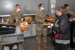 U.S. Army Pvt. Harold Taylor and Spc. Jo England, communications operators, 1st Battalion 157th Infantry Regiment, Colorado Army National Guard serve food to the guests at the Denver Rescue Mission, April 20, 2020. The Soldiers helped a man who was choking on food.