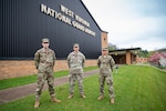 Senior Airman Will Wagstaff (left), Maj. Ryan Coss (center) and Senior Airman Carly Farmer pose for a photo outside the West Virginia National Guard Joint Forces Headquarters in Charleston, W.Va. Coss, Wagstaff and Farmer are serving as a part of Task Force Petersen, the task force dedicated to procuring and forecasting demand for critical personal protective equipment for the State of West Virginia's response to the ongoing COVID-19 pandemic. (U.S. Air National Guard photo by Staff Sgt. Caleb Vance.)