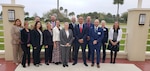 Group photo of men and women wearing professional work attire standing outside