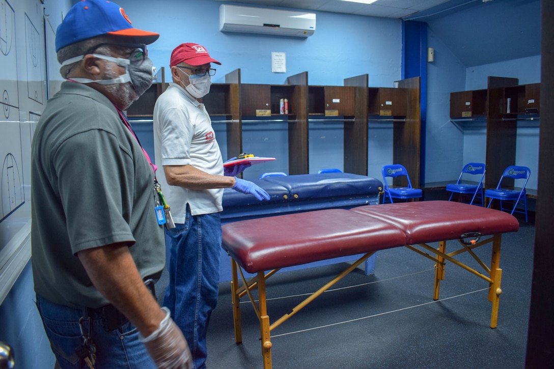 Marcial Garai speaking to a male local representative during in a locker room