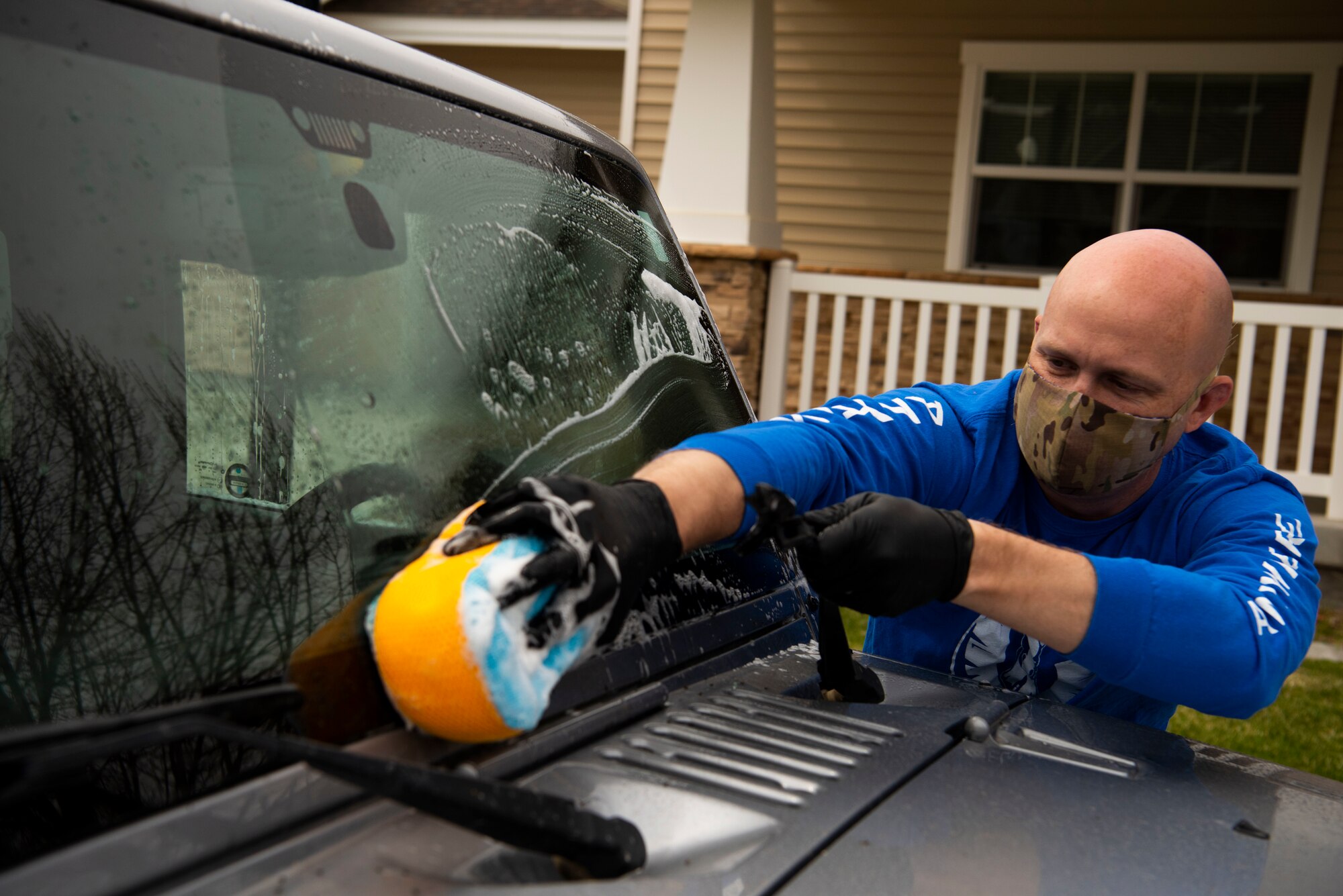 U.S. Air Force Tech. Sgt. Joshua Armstrong, 366th Operation Support Squadron radar approach control supervisor, cleans a car, April 22, 2020, at Mountain Home Air Force Base, Idaho. Airmen from the 366th OSS have been giving back to the community by helping do day-to-day tasks for families during the COVID-19 pandemic. (U.S. Air Force photo by Airman 1st Class Andrew Kobialka)