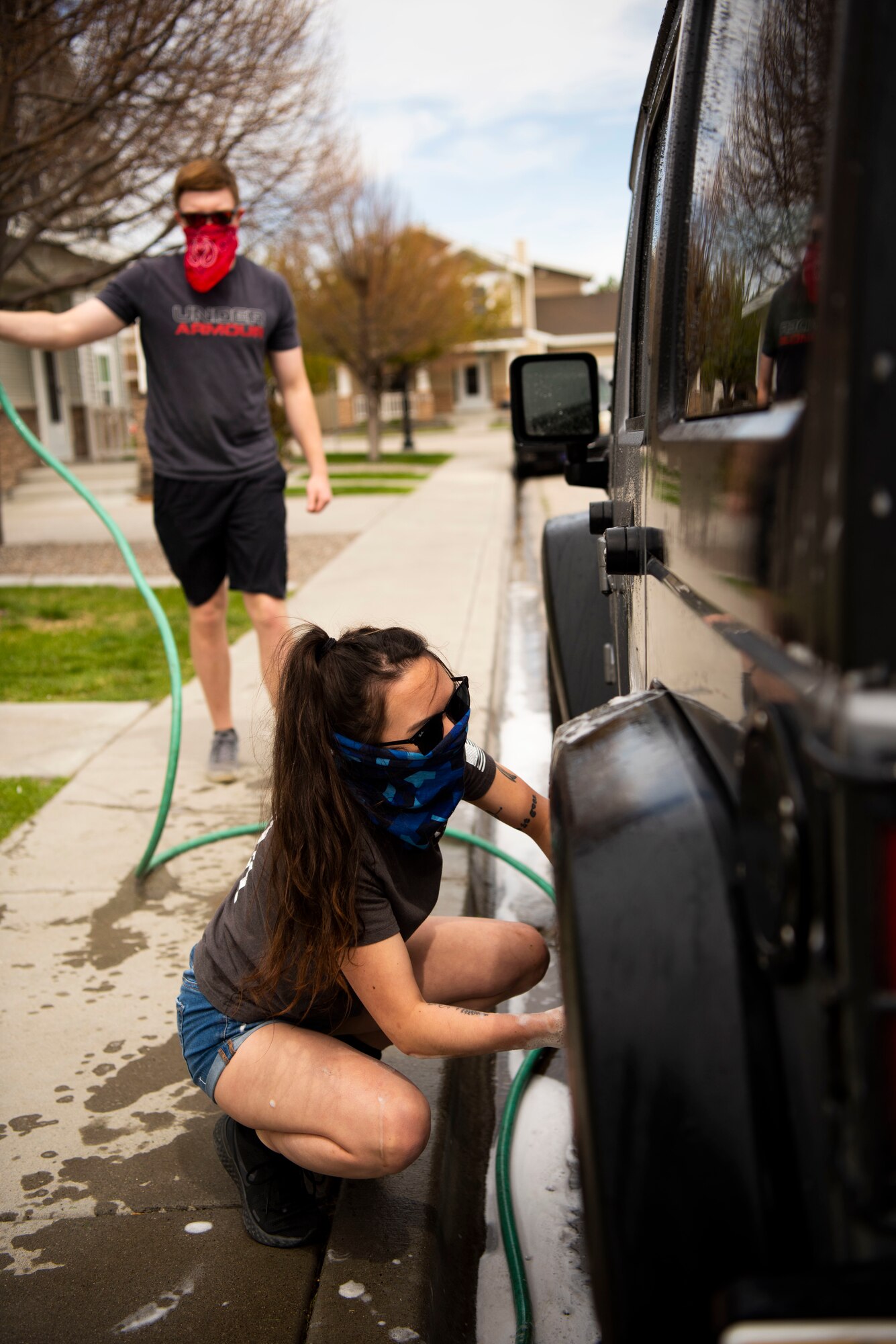 U.S. Air Force Airman 1st Class Yuri Rowe (front) and U.S. Air Force Airman 1st Class Christopher Ivers (back), both 366th Operation Support Squadron radar approach control supervisor, clean a car, April 22, 2020, at Mountain Home Air Force Base, Idaho. Airmen from the 366th OSS have been giving back to the community by helping do day-to-day tasks for families during the COVID-19 pandemic. (U.S. Air Force photo by Airman 1st Class Andrew Kobialka)