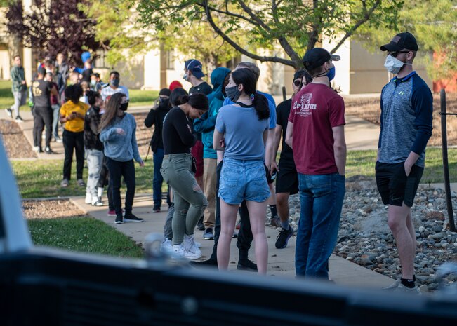 Airmen wait in line for meals secured by the Chaplain Corps and dorm leadership