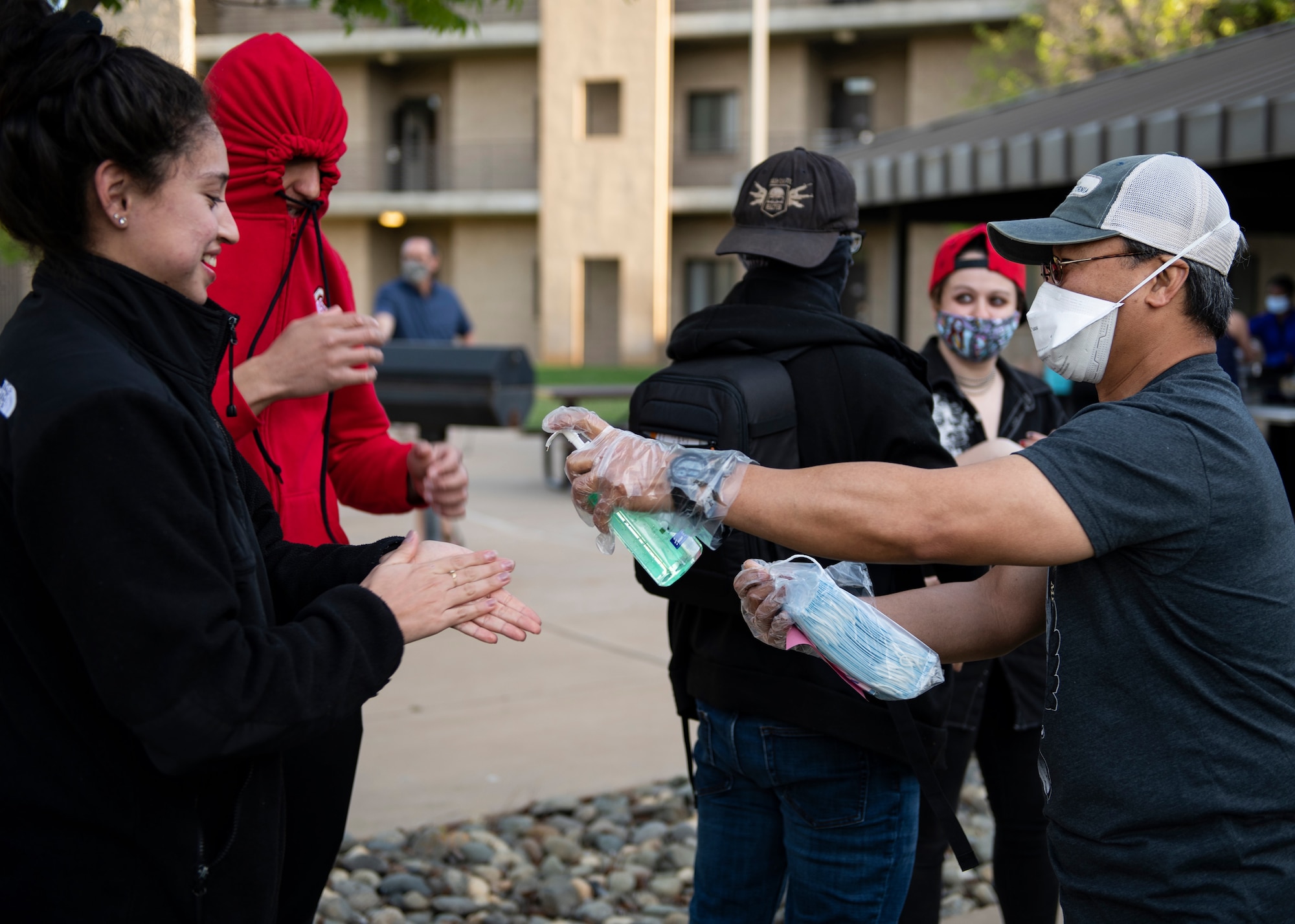 U.S. Air Fore Maj. Mario Rosario gives hand sanitizer and face masks to Airmen.