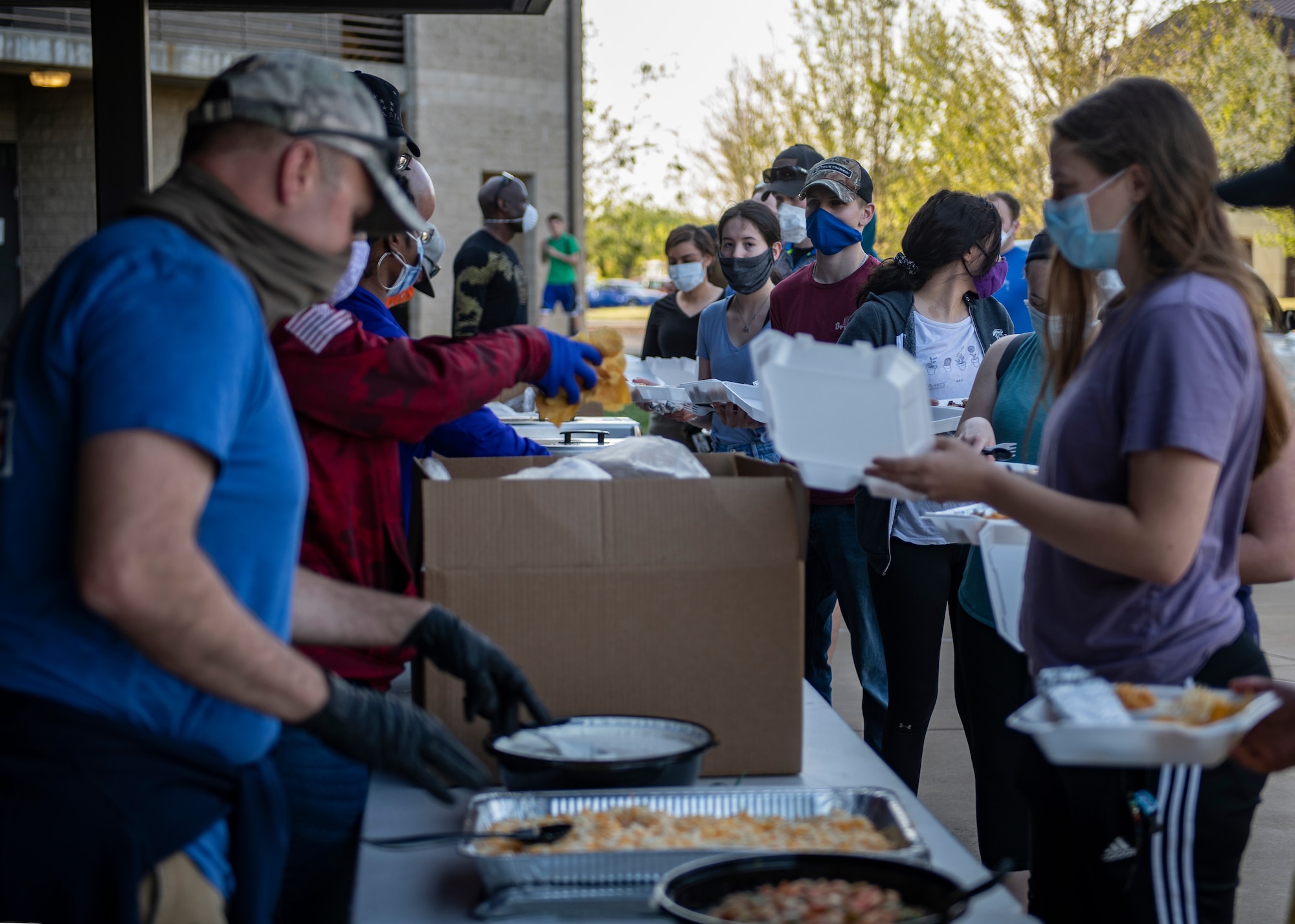 Airmen receive food from members of the Chaplain Corps and dorm leadership.