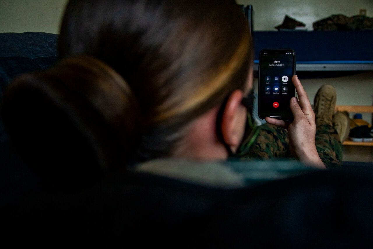 A Marine talks to her mother on speaker phone.