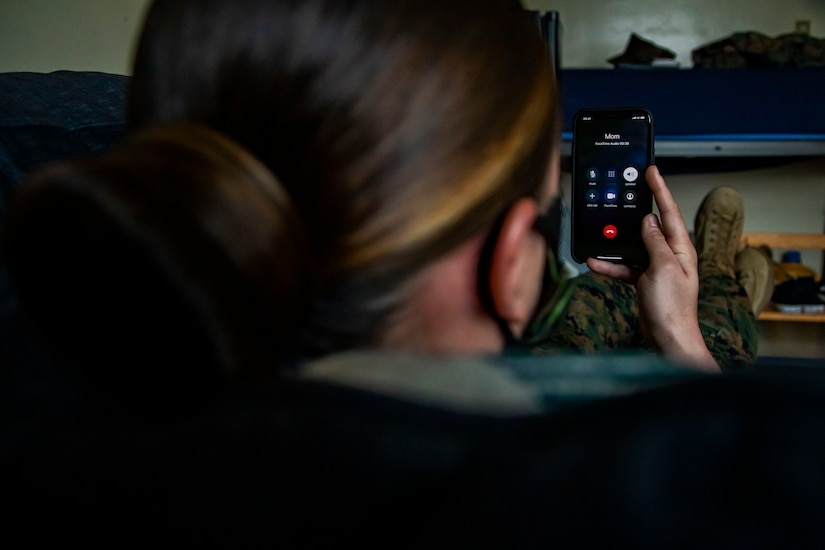 A Marine talks to her mother on speaker phone.
