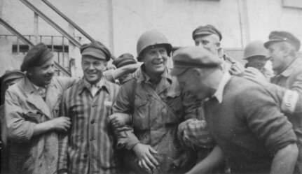 An American Soldier is surrounded by survivors at the newly liberated Dachau concentration camp, April 29, 1945, in Dachau, Germany. American Soldiers of the U.S. 7th Army, including members of the 42nd Infantry and 45th Infantry and 20th Armored Divisions, participated in the camp’s liberation.
