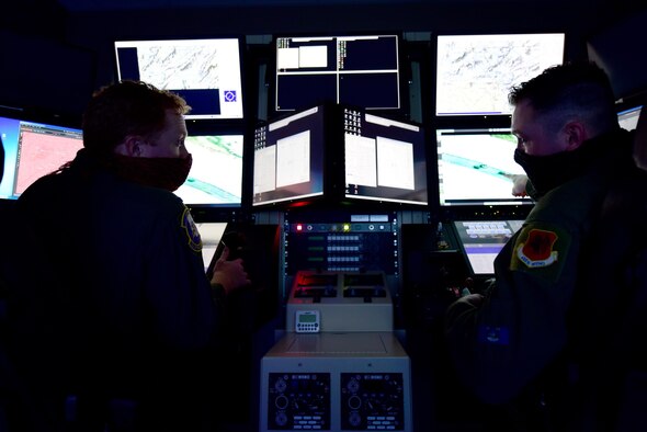 MQ-9 Reaper aircrew from the 22nd Attack Squadron, 1st Lt. Robert, pilot, and Staff Sgt. Edward, sensor operator, look to one another while flying a training mission at Creech Air Force Base, Nevada, April 15, 2020. The 22nd Attack Squadron, and other squadrons within the 432nd Wing/432nd Air Expeditionary Wing, provide critical dominant, persistent attack and reconnaissance capabilities in the defense of the Nation 24/7/365. (U.S. Air Force photo by Airman 1st Class William Rio Rosado)