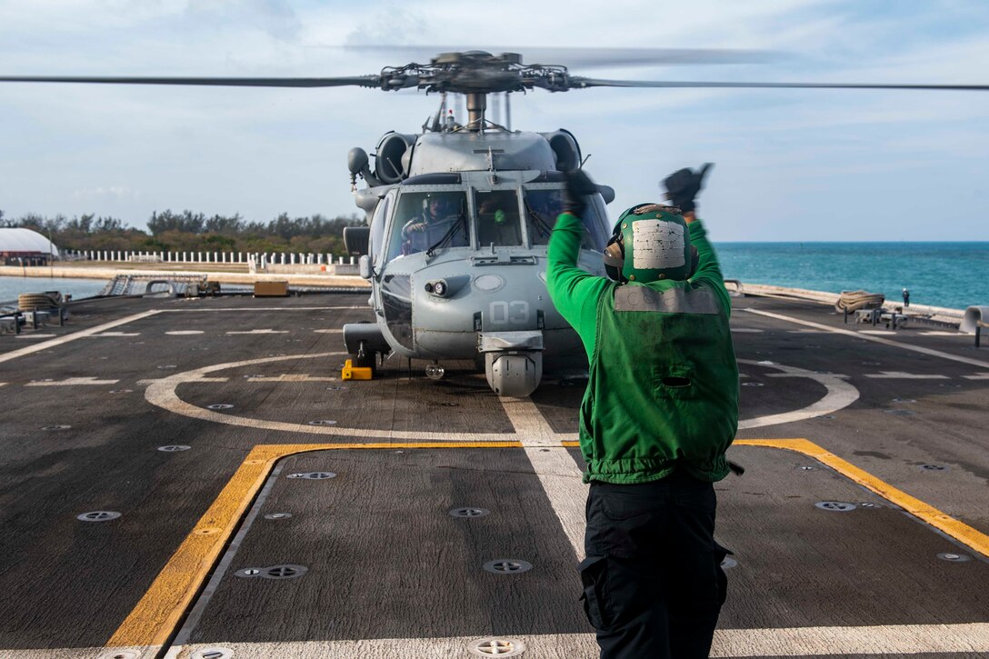 A person signals to a helicopter.