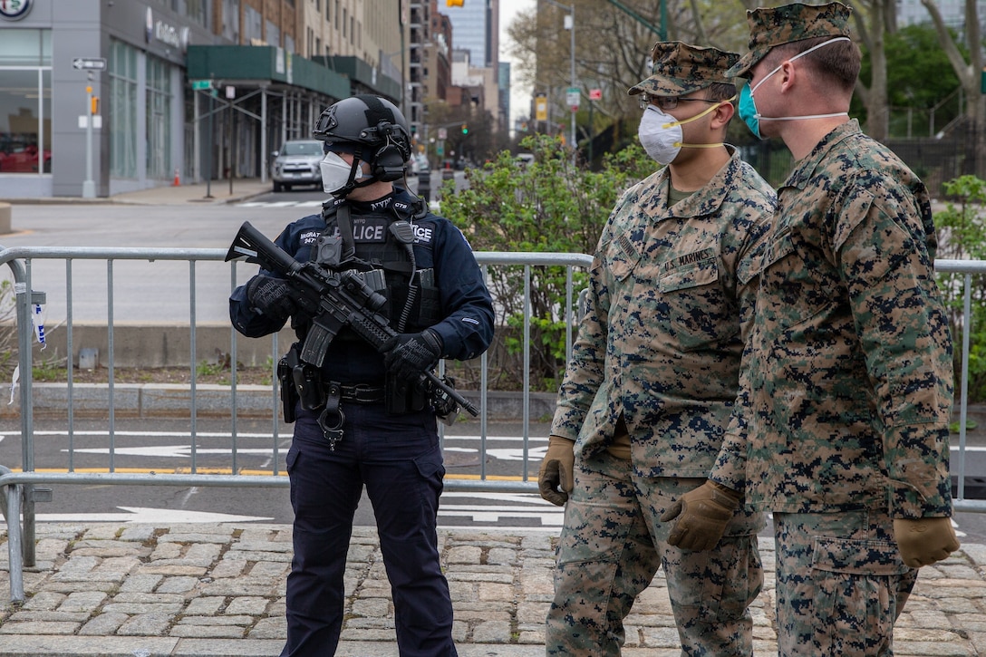 Police officer Ron McGrattan with the Critical Response Command in the Counterterrorism Bureau of the New York City Police Department post security for the hospital ship USNS Comfort (T-AH 20) alongside Lance Cpl. Matthew Aquino, center, and Cpl. Timothy Pennington, both rifleman with Lima Company, 3rd Battalion, 2nd Marine Regiment , Task Force New York in New York City, April 23, 2020. Comfort cares for trauma, emergency and urgent care patients without regard to their COVID-19 status. Comfort is working with the Javits New York Medical Station as an integrated system to relieve the New York City medical system, in support of U.S. Northern Command's Defense Support of Civil Authorities as a response to the COVID-19 pandemic. (U.S. Marine Corps photo by Sgt. Stormy Mendez)