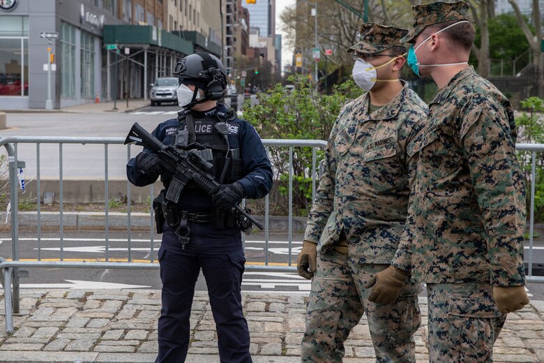 Police officer Ron McGrattan with the Critical Response Command in the Counterterrorism Bureau of the New York City Police Department post security for the hospital ship USNS Comfort (T-AH 20) alongside Lance Cpl. Matthew Aquino, center, and Cpl. Timothy Pennington, both rifleman with Lima Company, 3rd Battalion, 2nd Marine Regiment , Task Force New York in New York City, April 23, 2020. Comfort cares for trauma, emergency and urgent care patients without regard to their COVID-19 status. Comfort is working with the Javits New York Medical Station as an integrated system to relieve the New York City medical system, in support of U.S. Northern Command's Defense Support of Civil Authorities as a response to the COVID-19 pandemic. (U.S. Marine Corps photo by Sgt. Stormy Mendez)