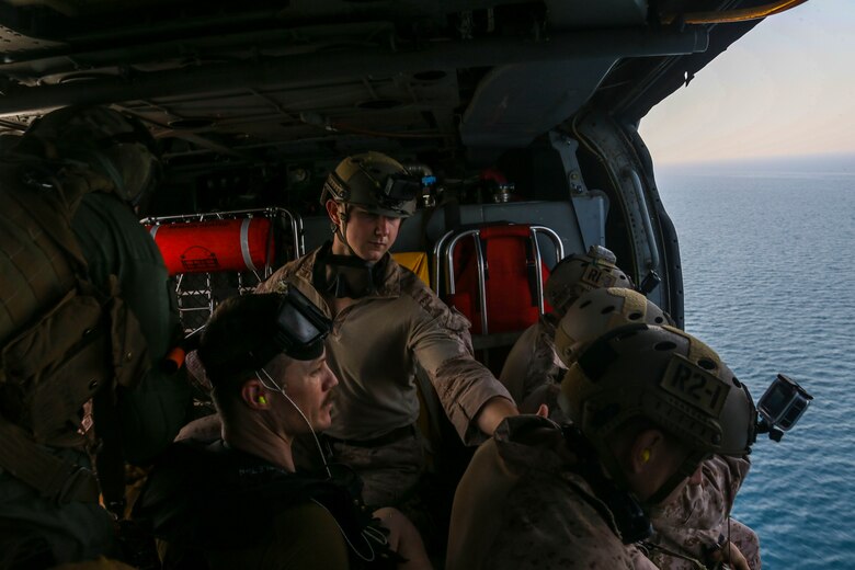 Reconnaissance Marines assigned to the Maritime Raid Force, 26th Marine Expeditionary Unit, and Sailors assigned to the amphibious assault ship USS Bataan (LHD 5) prepare to jump into the ocean during helocasting training in the U.S. Navy's 5th Fleet area of responsibility, April 23, 2020. Bataan, with embarked 26th MEU, is deployed to the U.S. 5th Fleet area of operations in support of naval operations to ensure maritime stability and security in the Central Region, connecting the Mediterranean and Pacific through the Western Indian Ocean and three strategic choke points. (U.S. Marine Corps photo by Cpl. Tanner Seims)