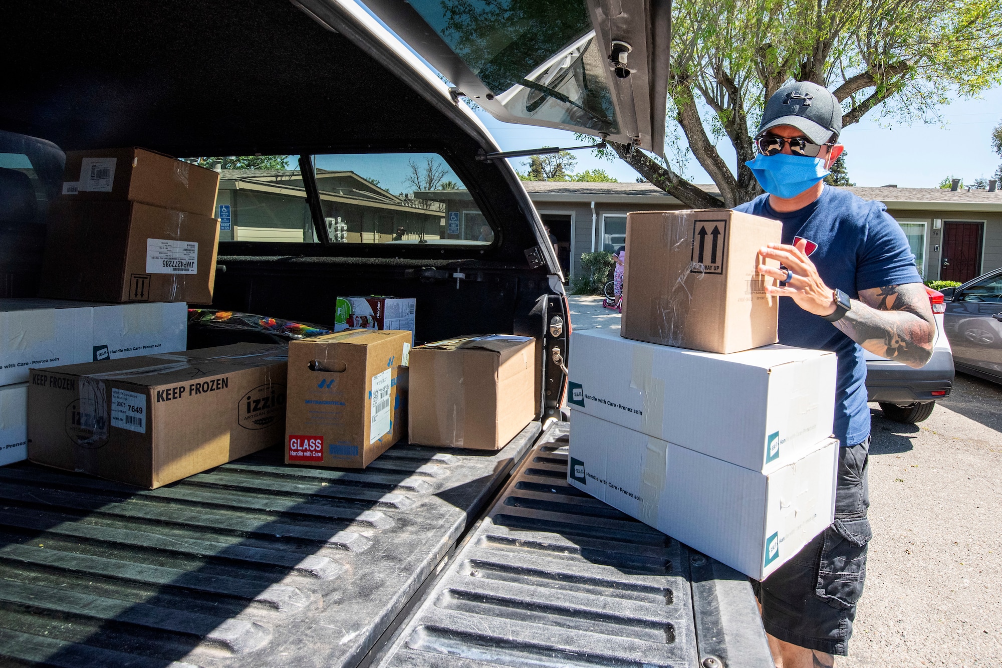 Tech. Sgt. Steve Rogers, 921st Contingency Response Squadron aerial porter, stacks boxes to be carried into The Leaven after-school program building in Vacaville, California, April 24, 2020. Supplies at many regional food pantries have been scarce since the beginning of the coronavirus outbreak. (U.S. Air Force photo by Tech. Sgt. David W. Carbajal)