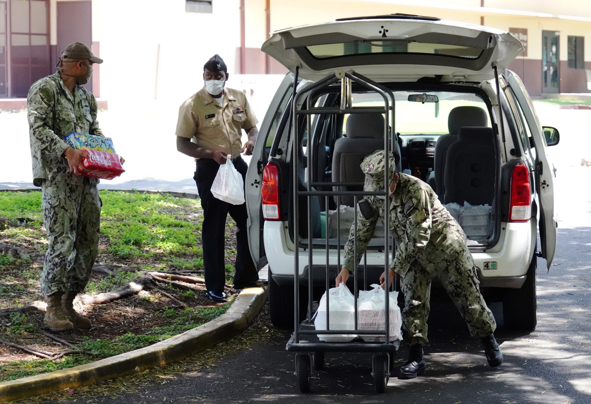 U.S. Navy Sailors volunteering for the COVID-19 Support Team unload meals from the Hale Aina Dining Facility on Joint Base Pearl Harbor-Hickam, Hawaii, April 16, 2020. The program delivers meals and essentials to military personnel placed on restriction of movement due to the COVID-19 pandemic. (U.S. Air Force photo by Airman 1st Class Erin Baxter)