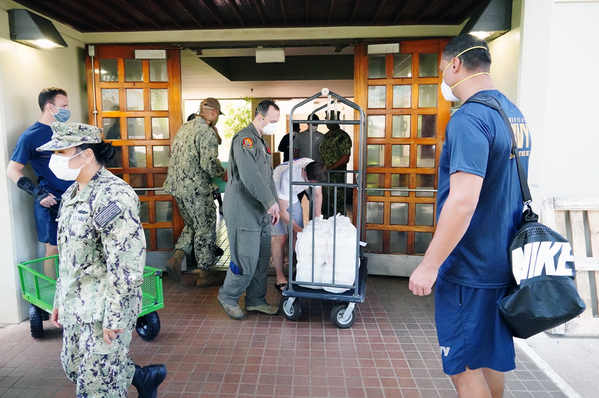 U.S. Navy Sailors and U.S. Air Force Airmen deliver meals from the Hale Aina Dining Facility to newly arrived personnel placed on restriction of movement on Joint Base Pearl Harbor-Hickam, Hawaii, April 16, 2020. Volunteers with the COVID-19 Support Team distributed meals and essentials to ROM military personnel in the midst of the COVID-19 pandemic. (U.S. Air Force photos by Airman 1st Class Erin Baxter)
