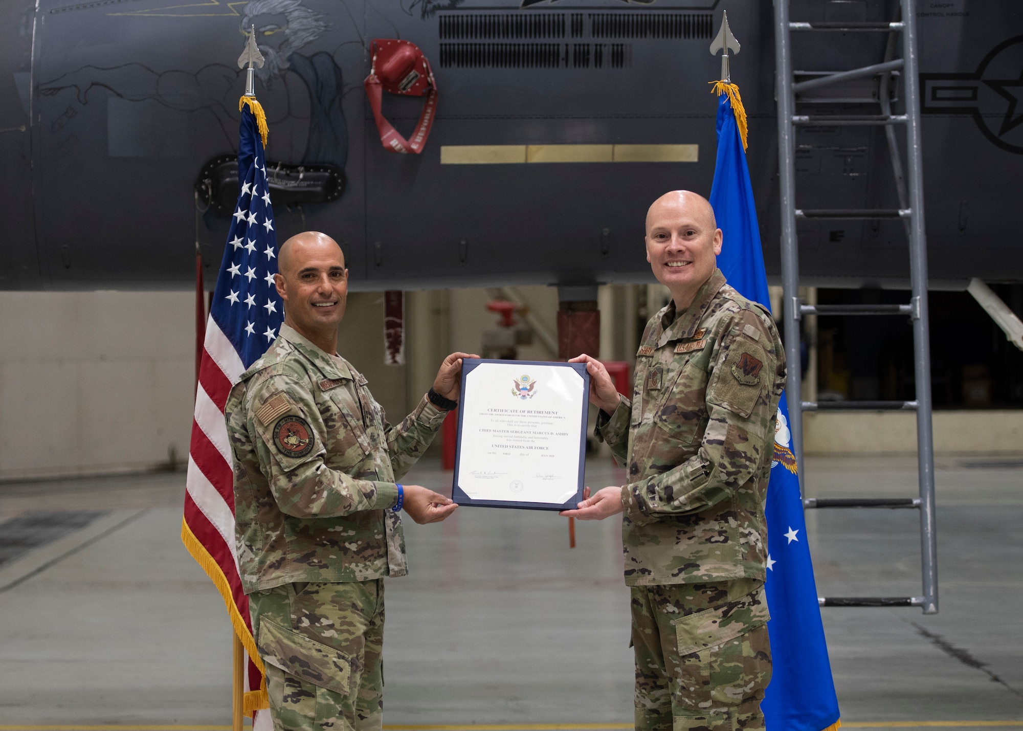 U.S. Air Force Col. Tony Lombardo, 366th Fighter Wing Chief of Staff, presents Chief Master Sgt. Marcus Ashby, 366th Fighter Wing A4 superintendent, the certificate of retirement April 16, 2020, on Mountain Home Air Force Base, Idaho. Due to the COVID-19 pandemic, Ashby came up with the idea of conducting a virtual retirement ceremony through video clips, providing a unique ceremony that not only acknowledges his career but also adapts to the changes of MHAFB. (U.S. Air Force photo by Airman 1st Class Akeem K. Campbell)