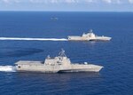 The Independence-variant littoral combat ships USS Montgomery (LCS 8), bottom, and USS Gabrielle Giffords (LCS 10) operate in the South China Sea, accompanied by an MH-60S Sea Hawk of Helicopter Sea Combat Squadron (HSC) 23, Jan. 28, 2020. Jan. 28, 2020. Montgomery and Gabrielle Giffords are on rotational deployments to USINDOPACOM, conducting operations, exercises and port visits throughout the region and working hull-to-hull with allied and partner navies to provide maritime security and stability, key pillars of a free and open Indo-Pacific.