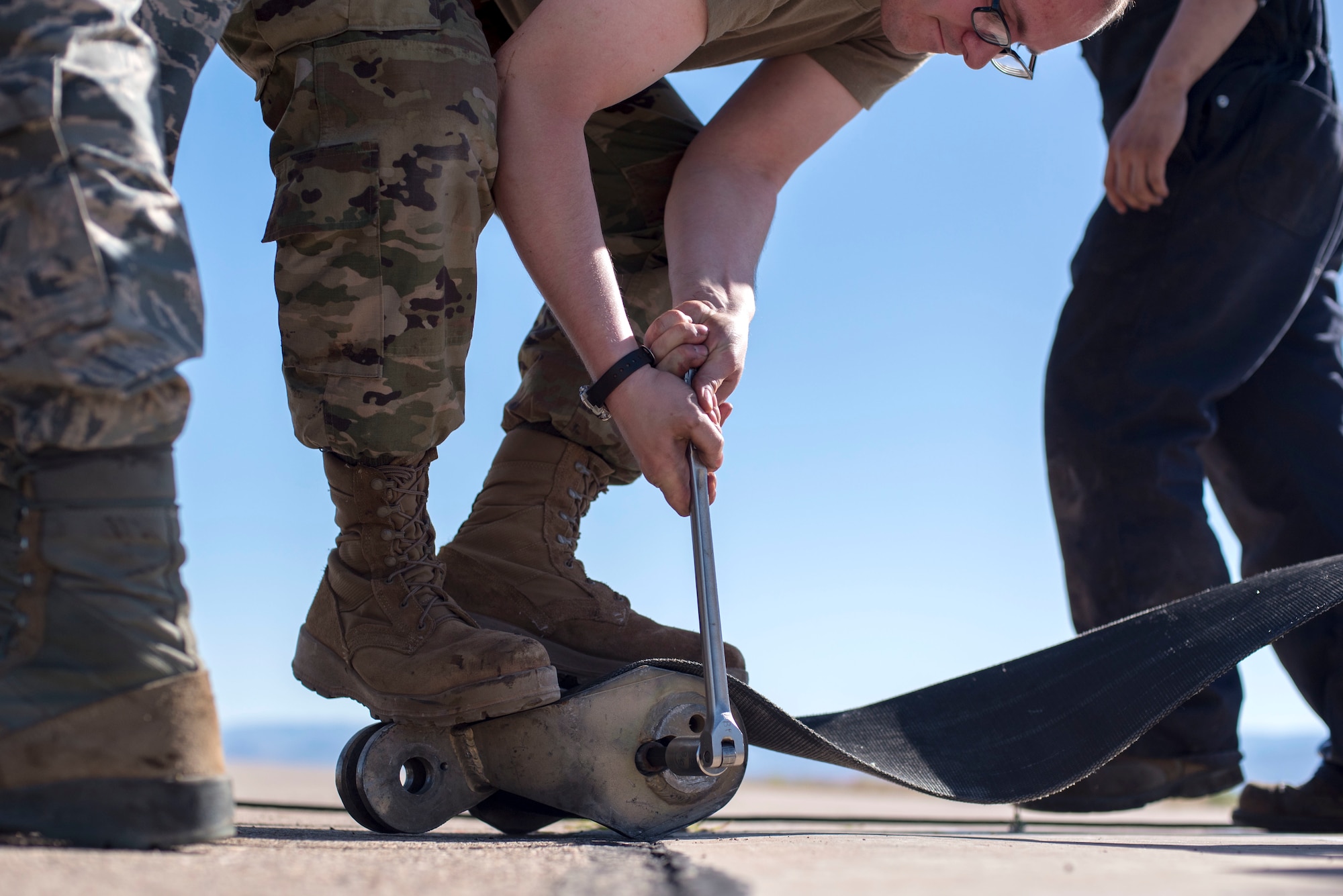 Airman 1st Class Curtis Mark, 49th Civil Engineer Squadron electrical power production technician, reinstalls a tape connector on the flightline, on Holloman Air Force Base, N.M., April 21, 2020. The tape connector is part of a BAK-15 Aircraft Arrest System Barrier, which helps pilots safely stop their aircraft in case of an aircraft emergency. (U.S. Air Force photo by Staff Sgt. Christine Groening)