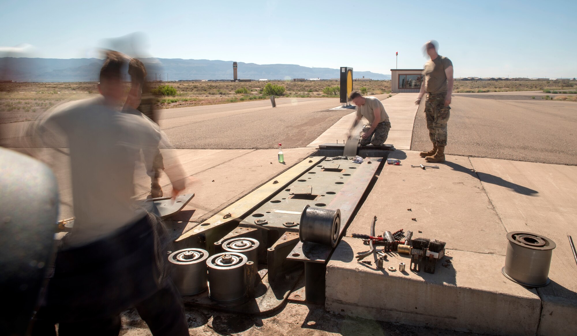Airmen from the 49th Civil Engineer Squadron electrical power production shop reassemble a barrier on the flightline, on Holloman Air Force Base, N.M., April 21, 2020. The Airmen’s daily responsibilities include inspecting and servicing items across base such as the power supply to buildings, anti-vehicle barriers and aircraft arresting system barriers. (U.S. Air Force photo by Staff Sgt. Christine Groening)