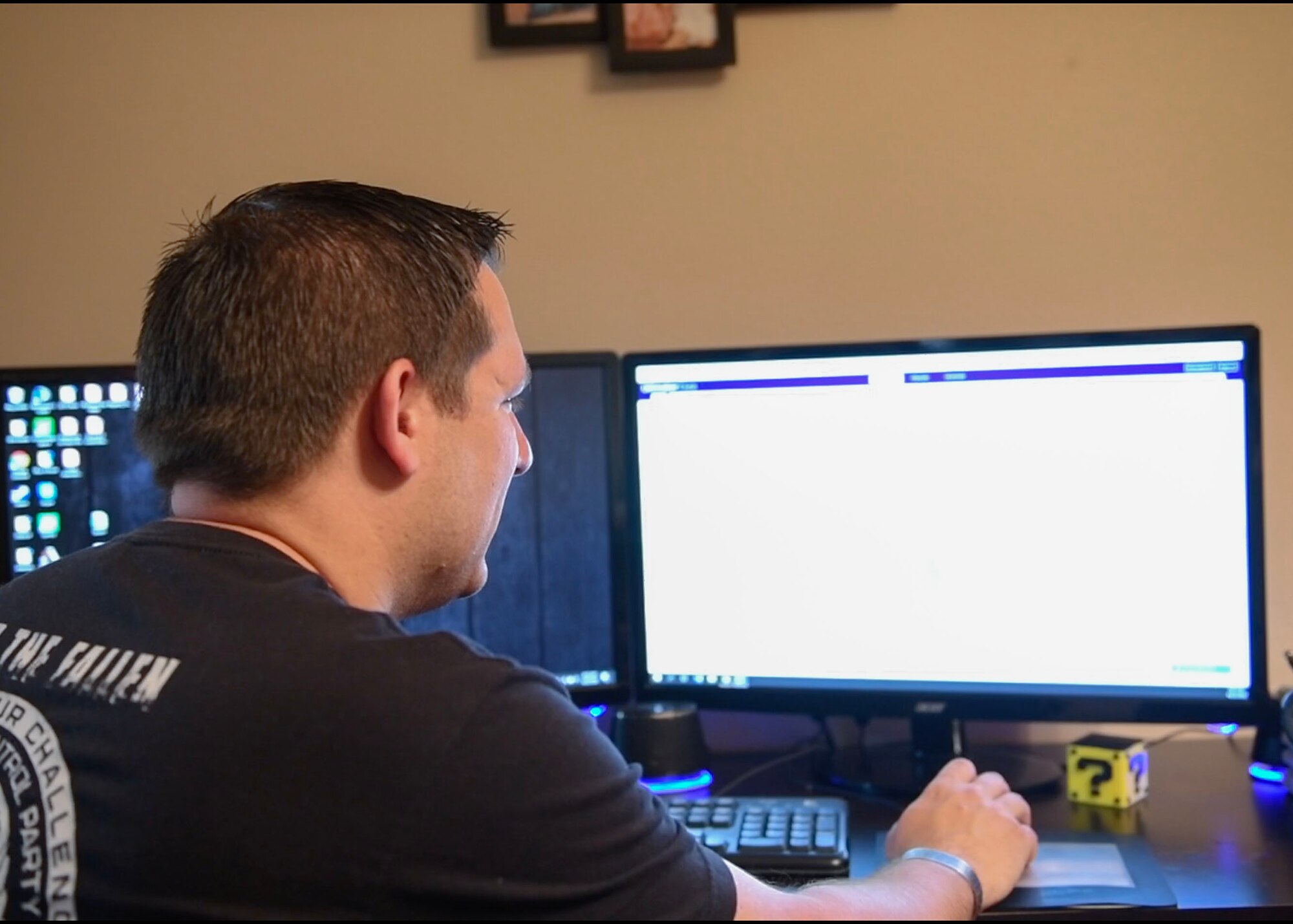 A man sits behind a computer.