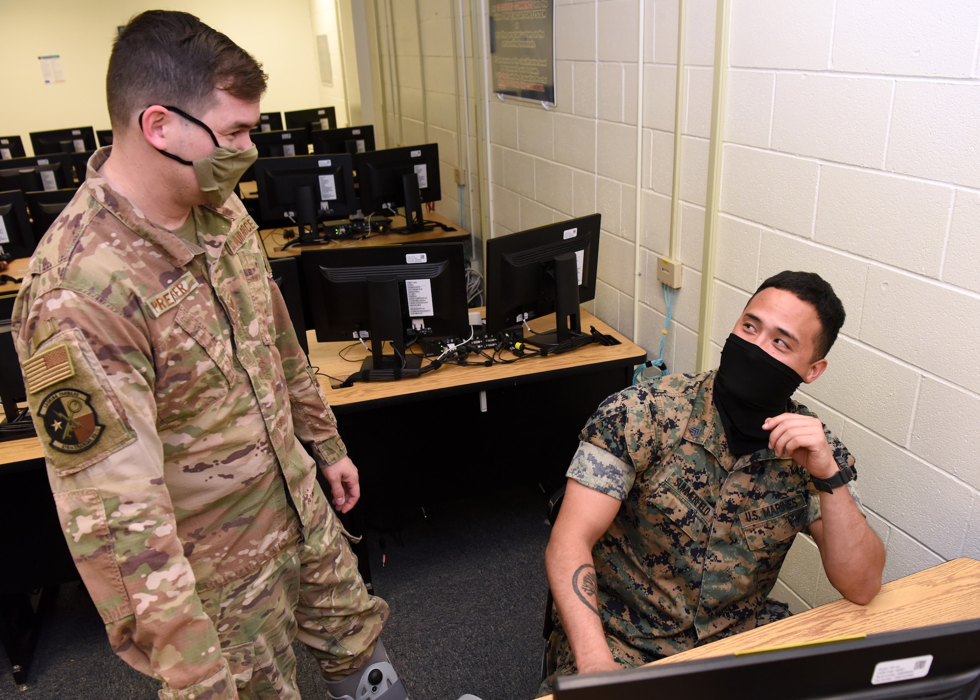 U.S. Air Force Staff Sgt. Jonathan Preiser, 316th Training Squadron instructor, engages with Marine Corps Staff Sgt. Terry Summerfield, Marine Corps Detachment student, during the in-classroom portion of the Apprentice Electronic Signals Intelligence Analyst (1N2A) course inside Fred Sebers Hall on Goodfellow Air Force Base, Texas, April 20, 2020. The classroom complied with the 17th Training Wing and federal safety regulations during the COVID-19 pandemic and shifted two-thirds of its material to digital. (U.S. Air Force Photo by Airman 1st Class Abbey Rieves)
