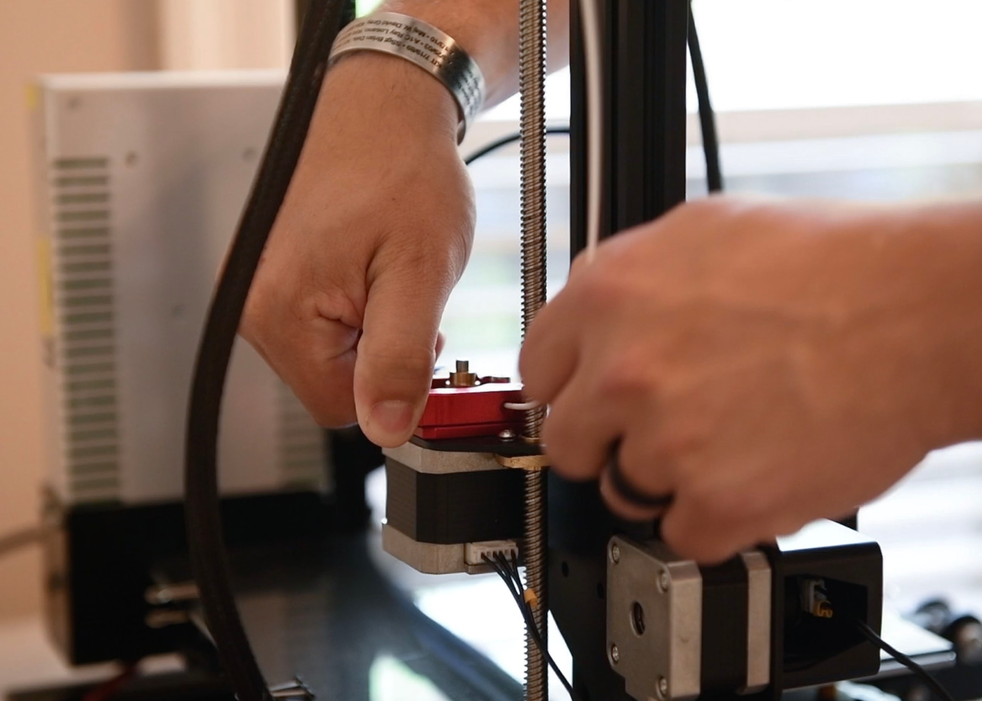 A man puts filament into a 3D printer.