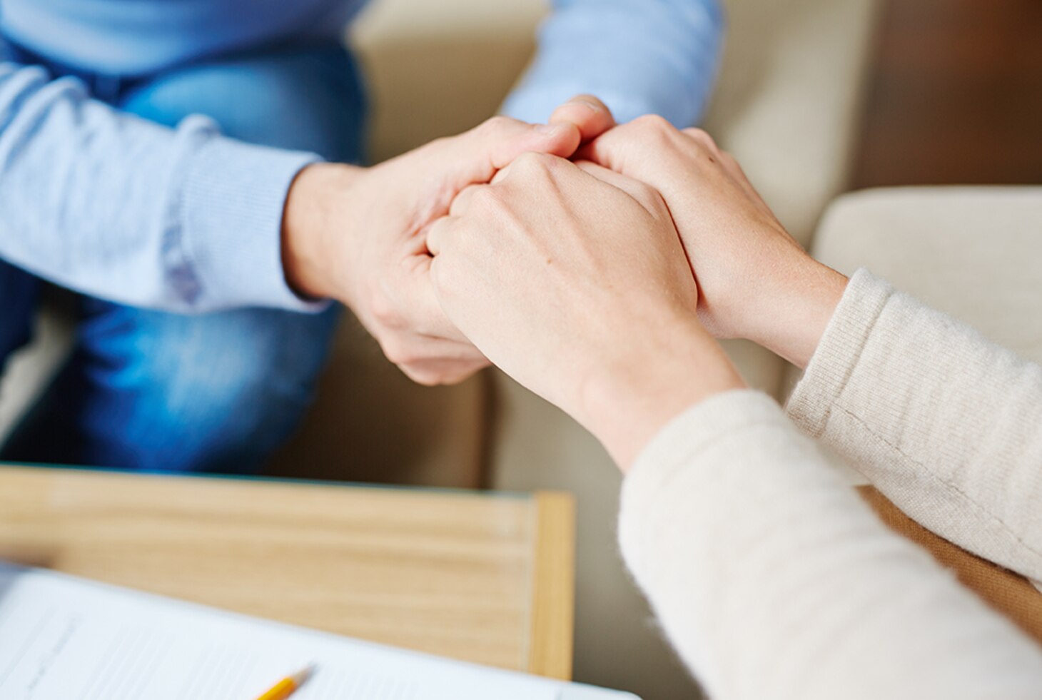 Two pairs of outstretched hands holding each other