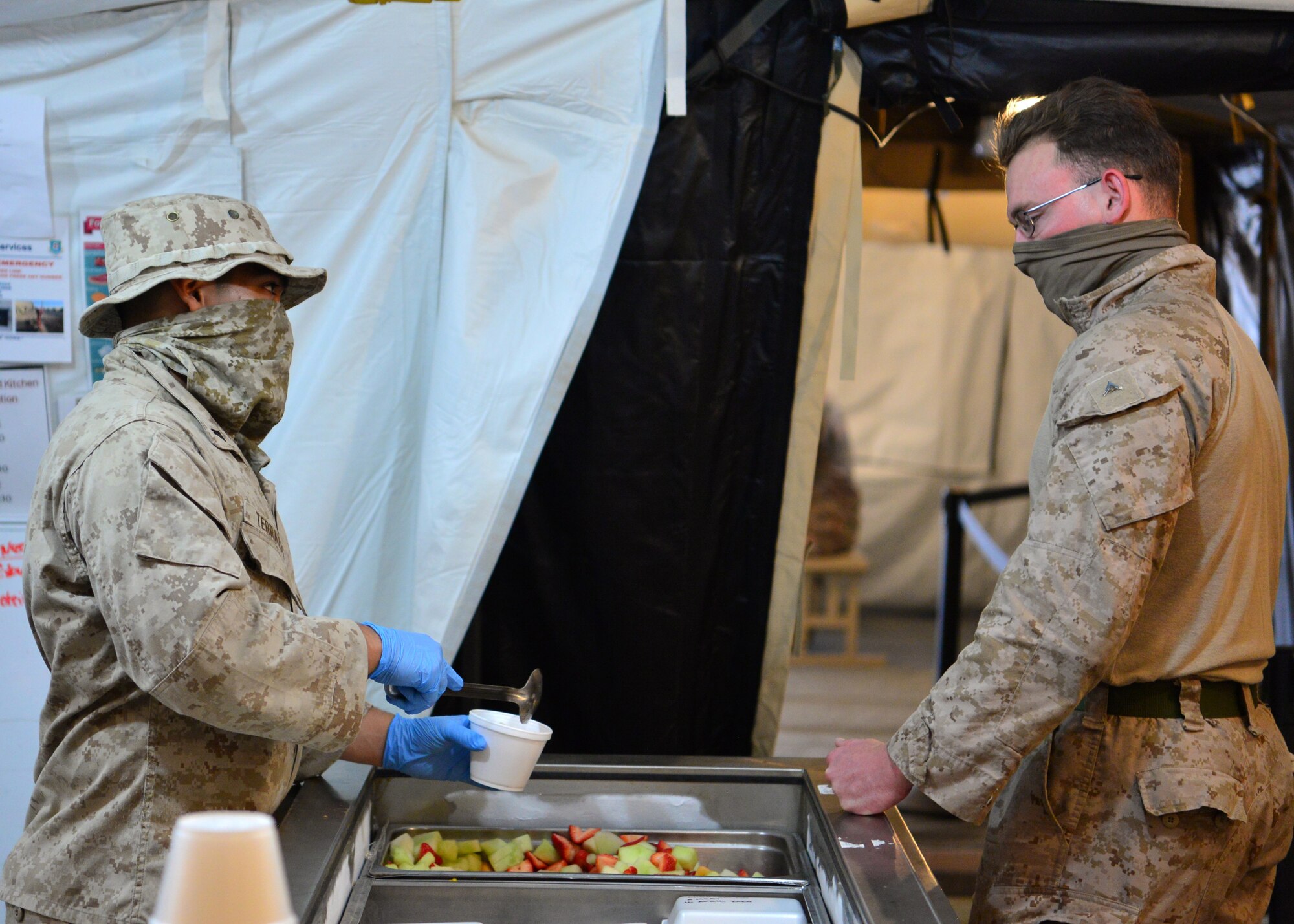 A U.S. Marine Corps volunteer prepares a meal for a fellow Marine at the Sandstorm field kitchen, Ahmed Al Jaber Air Base, Kuwait, April 17, 2020. The Sandstorm was stood up in an effort to further adhere to health protection levels by providing an additional avenue for customers to have a meal. (U.S. Air Force photo by Senior Airman Isaiah J. Soliz)