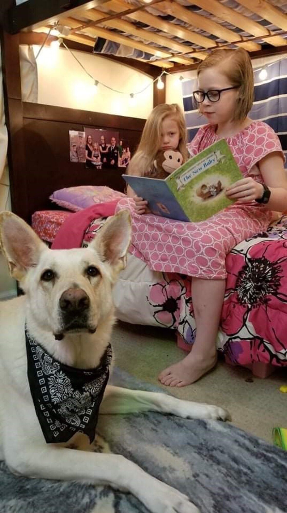 Photo of two kids and a dog sitting in a room