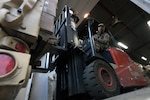 Spc. Jason Schollenberger, a truck driver with the Maryland Army National Guard’s 1229th Transportation Company, loads a pallet of food onto a medium tactical vehicle at the Maryland Food Bank Warehouse in Linthicum Heights, Md., April 24, 2020. As part of COVID-19 response efforts, Soldiers were helping state and local officials distribute food to schools and recreation centers throughout Baltimore.