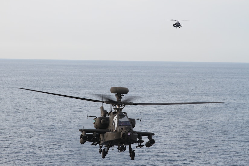 Two AH-64E Apache gunships land on the deck of the  Navy's the U.S.S. Lewis B. Puller during an at sea training exercise on April 15-16, 2020 in the Persian Gulf. The U.S. Army and the U.S. Navy work together to not only train but also too make both forces more effective. (U.S. Army photo by SGT. Andrew Winchell)