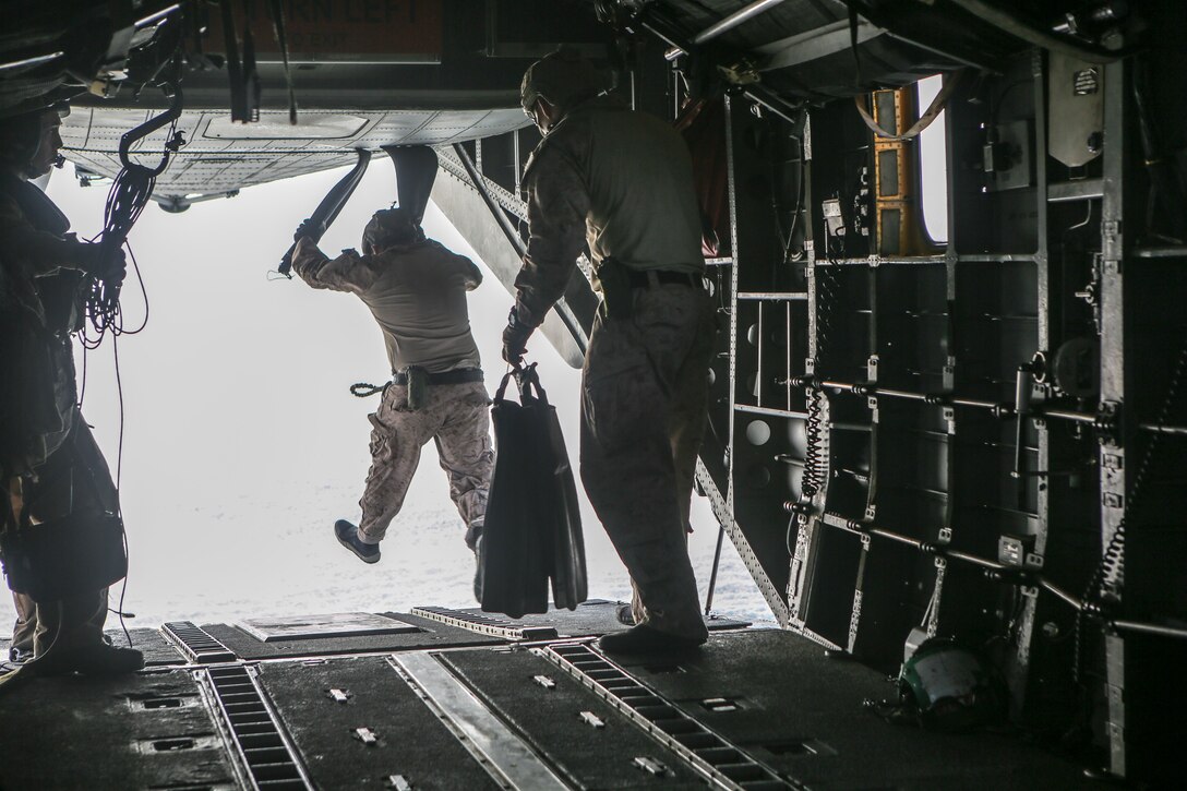 Marines assigned to the Maritime Raid Force, 26th Marine Expeditionary Unit, jump into the ocean from a CH-53E Super Stallion during helocasting training in the 5th Fleet area of operations, April 23, 2020. The 26th MEU is deployed to the U.S. 5th Fleet area of operations in support of naval operations to ensure maritime stability and security in the Central Region, connecting the Mediterranean and Pacific through the Western Indian Ocean and three strategic choke points. (U.S. Marine Corps photo by Cpl. Nathan Reyes)