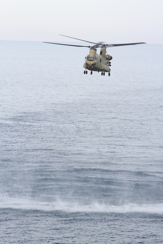 A Chinook fly’s over the water during a training exercise on April 15, 2020 in the Persian Gulf. The U.S. Army and the U.S. Navy work together to increase both their forces capabilities during a training exercise. (U.S. Army photo by SGT. Andrew Winchell)