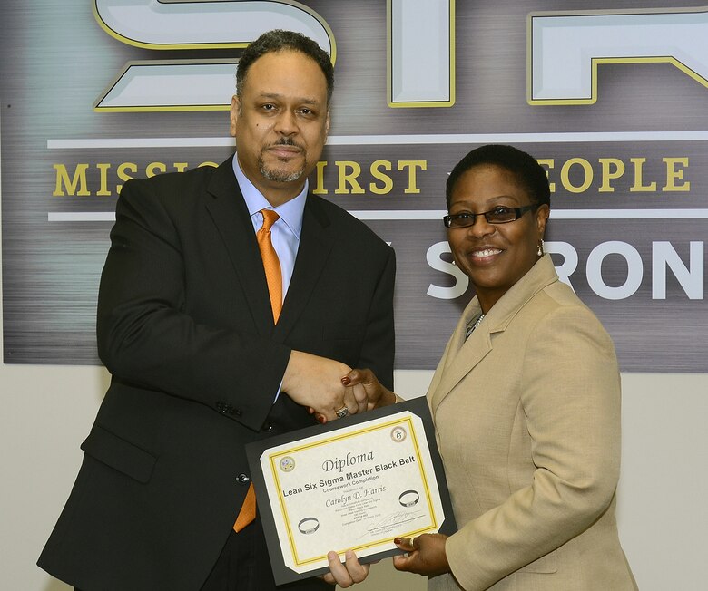 Dr. Charles Brandon, Director, Army Office of Business Transformation Process Improvement Program, awards Carolyn Harris, Huntsville Center's Program Improvement Manager, her Lean Six Sigma Master Black belt certificate in December. Harris is one of six MBBs in the U.S. Army Corps of Engineers.