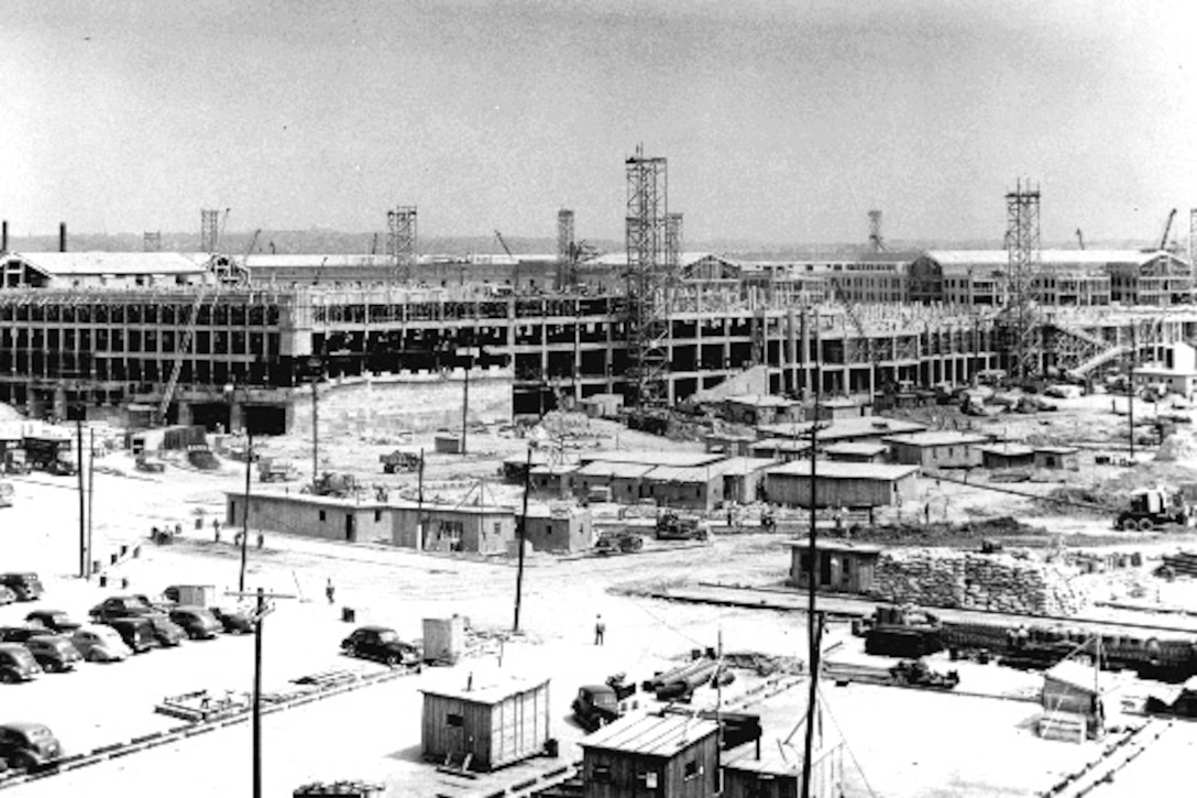 An old, black-and-white photo shows the construction of a large building.