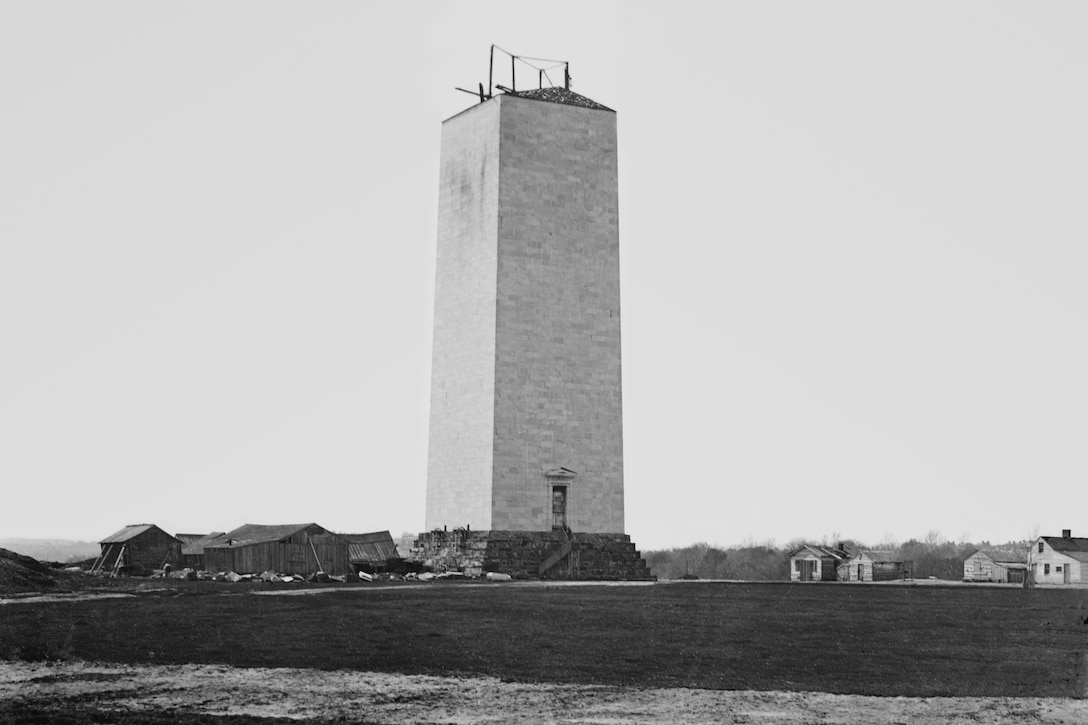 An old, black-and-white photo shows a structure under construction.