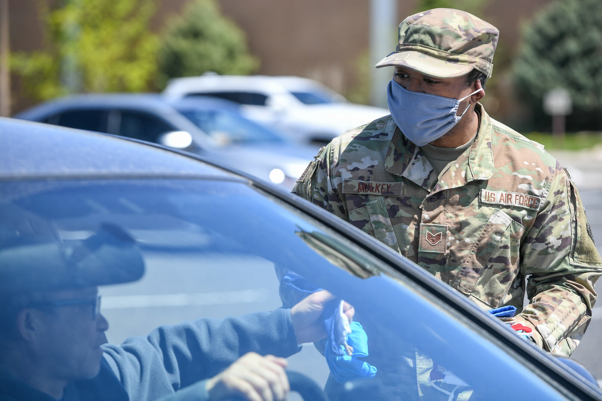 Staff. Sgt. Nicklas Mulkey, 75th Air Base Wing, hands out cloth masks to military and civilian Airmen April 28, 2020, at Hill Air Force Base, Utah. Around 4,000 masks, most donated from nearby communities and also from the 531st Armament Textile Shop, were given out to Team Hill to keep safe and healthy during the COVID-19 pandemic. (U.S. Air Force photo by Cynthia Griggs)