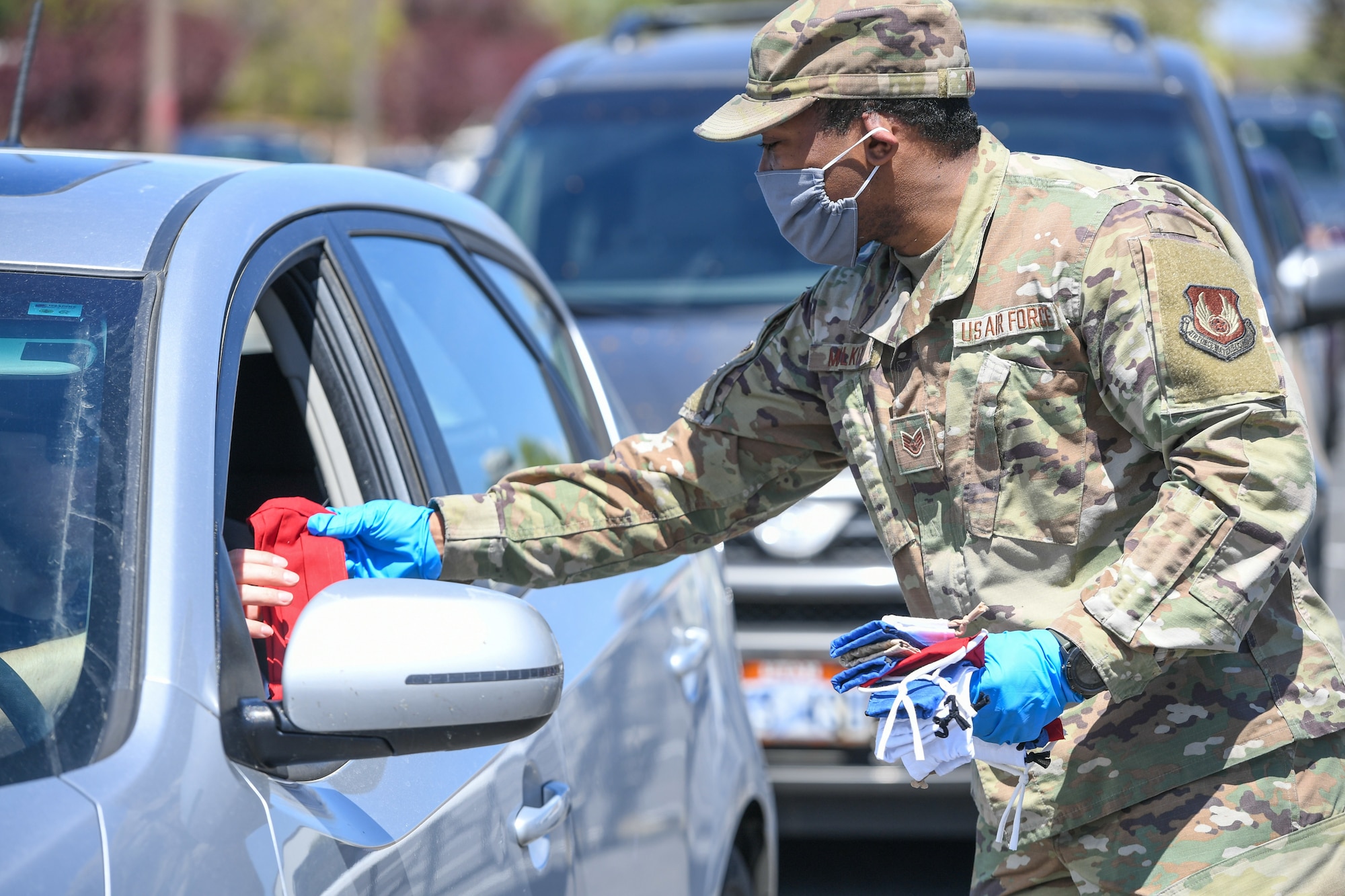 Staff. Sgt. Nicklas Mulkey, 75th Air Base Wing, hands out masks to military and civilian Airmen April 28, 2020, at Hill Air Force Base, Utah. Around 4,000 masks, most donated from nearby communities and also from the 531st Armament Textile Shop, were given out to Team Hill to keep safe and healthy during the COVID-19 pandemic. (U.S. Air Force photo by Cynthia Griggs)