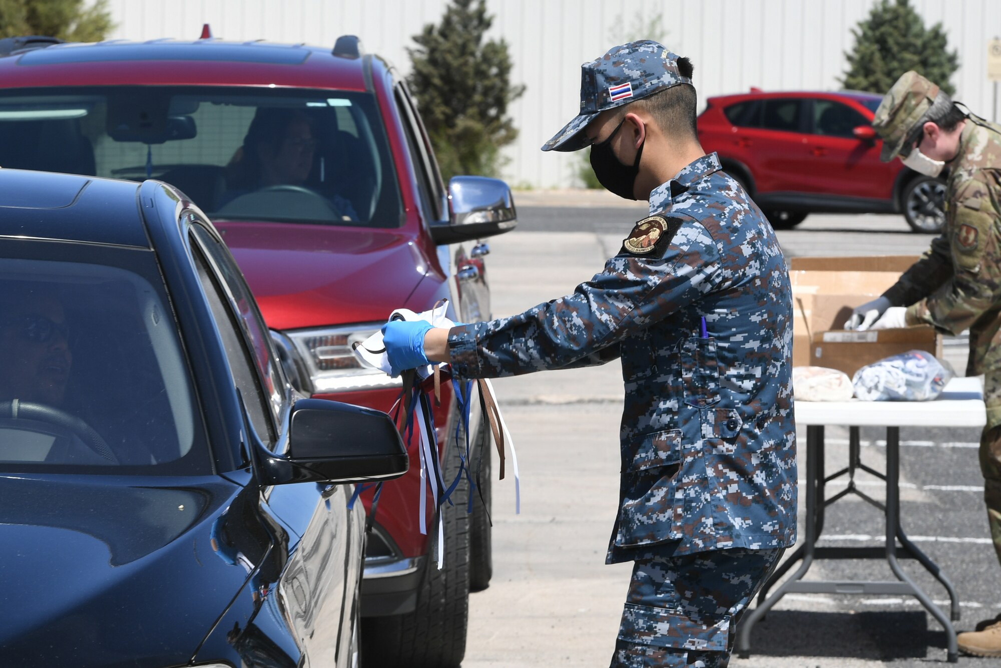 Capt. Krit Bualert, a Royal Thai Air Force officer assigned to 75th Logistics Readiness Squadron, hands out cloth masks to military and civilian Airmen April 28, 2020, at Hill Air Force Base, Utah. Around 4,000 masks, most donated from nearby communities and also from the 531st Armament Textile Shop, were given out to Team Hill to keep safe and healthy during the COVID-19 pandemic. (U.S. Air Force photo by Cynthia Griggs)