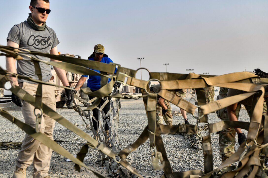 Photo of Airmen working on cargo nets