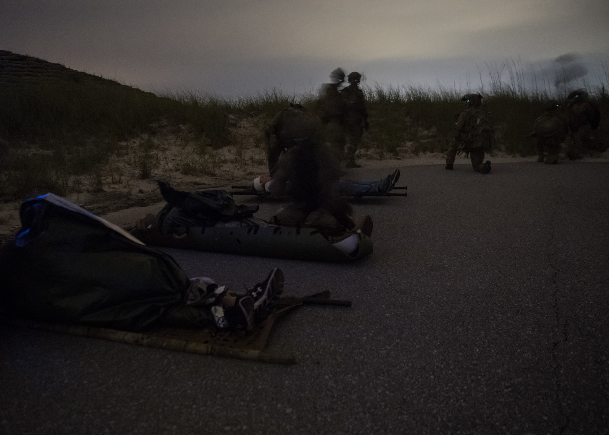 simulated patients lie spaced on stretchers in a road