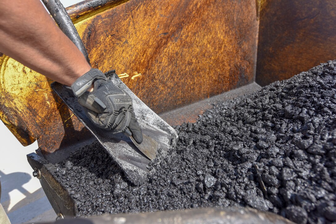 An Airman assigned to the 379th Expeditionary Civil Engineer Squadron cleans a shovel while repairing a section of damaged airfield at Al Udeid Air Base, Qatar on April 23, 2020. The Airfield had degraded, creating potential hazard from foreign objects. The 379 ECES monitors airfield conditions and makes needed repairs, enabling the 379th Air Expeditionary Wing to deliver airpower throughout the U.S. Air Forces Central Command area of responsibility. (U.S. Air Force photo by Tech. Sgt. John Wilkes)