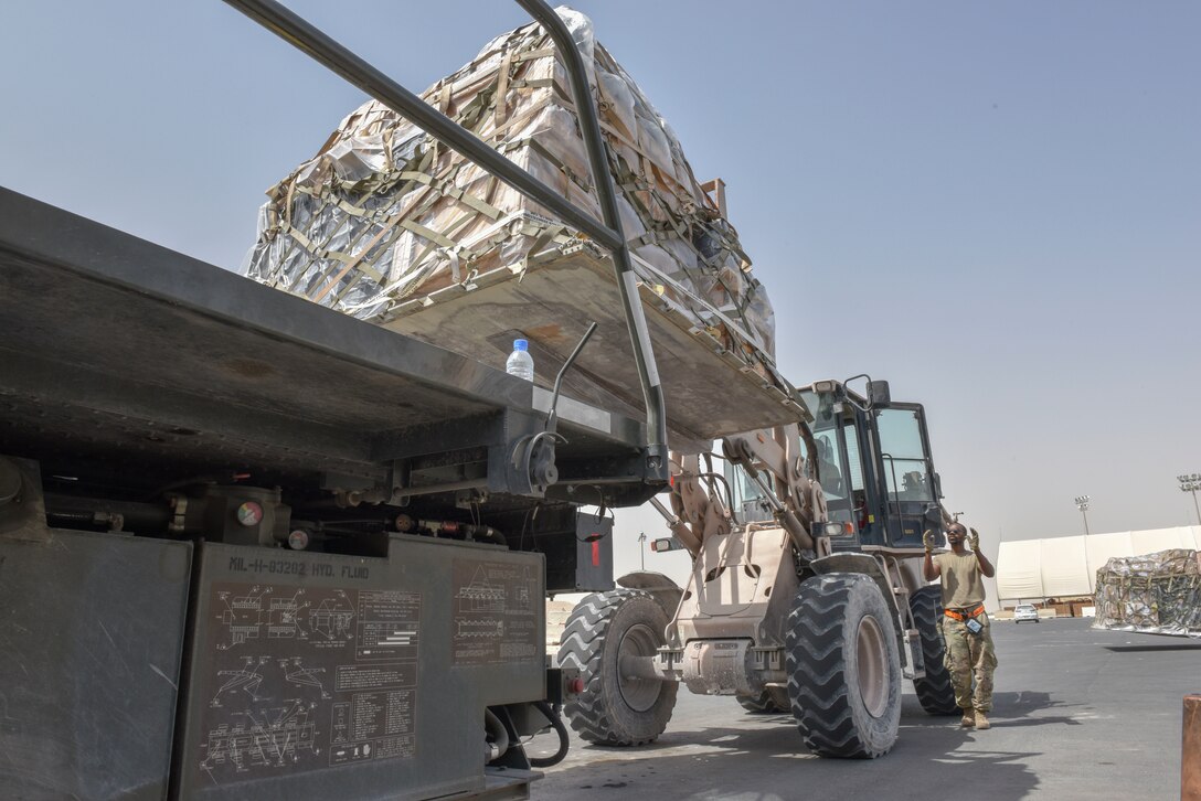Airmen with the 8th Expeditionary Air Mobility Squadron move cargo on the flightline at Al Udeid Air Base, Qatar on April 28, 2020. The 8 EAMS Airmen support dozens of missions per day, often moving hundreds of thousands of pounds of cargo and service members around the U.S. Air Forces Central Command area of responsibility. (U.S. Air Force photo by Tech. Sgt. John Wilkes)