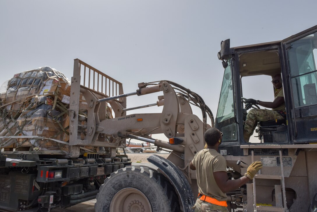 Airmen with the 8th Expeditionary Air Mobility Squadron move cargo on the flightline at Al Udeid Air Base, Qatar on April 28, 2020. The 8 EAMS Airmen support dozens of missions per day, often moving hundreds of thousands of pounds of cargo and service members around the U.S. Air Forces Central Command area of responsibility. (U.S. Air Force photo by Tech. Sgt. John Wilkes)